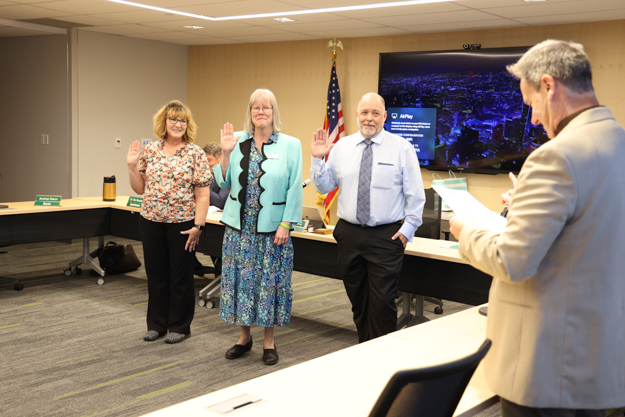 Board president Dr. Brian Gray, right, swears into office, from left, Lisa Kickbusch, Mary Kay Campbell and Daniel Wentz.